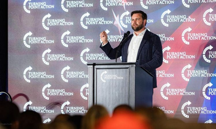 A picture of Usha Vance's husband, J. D. Vance speaking at an event. 
